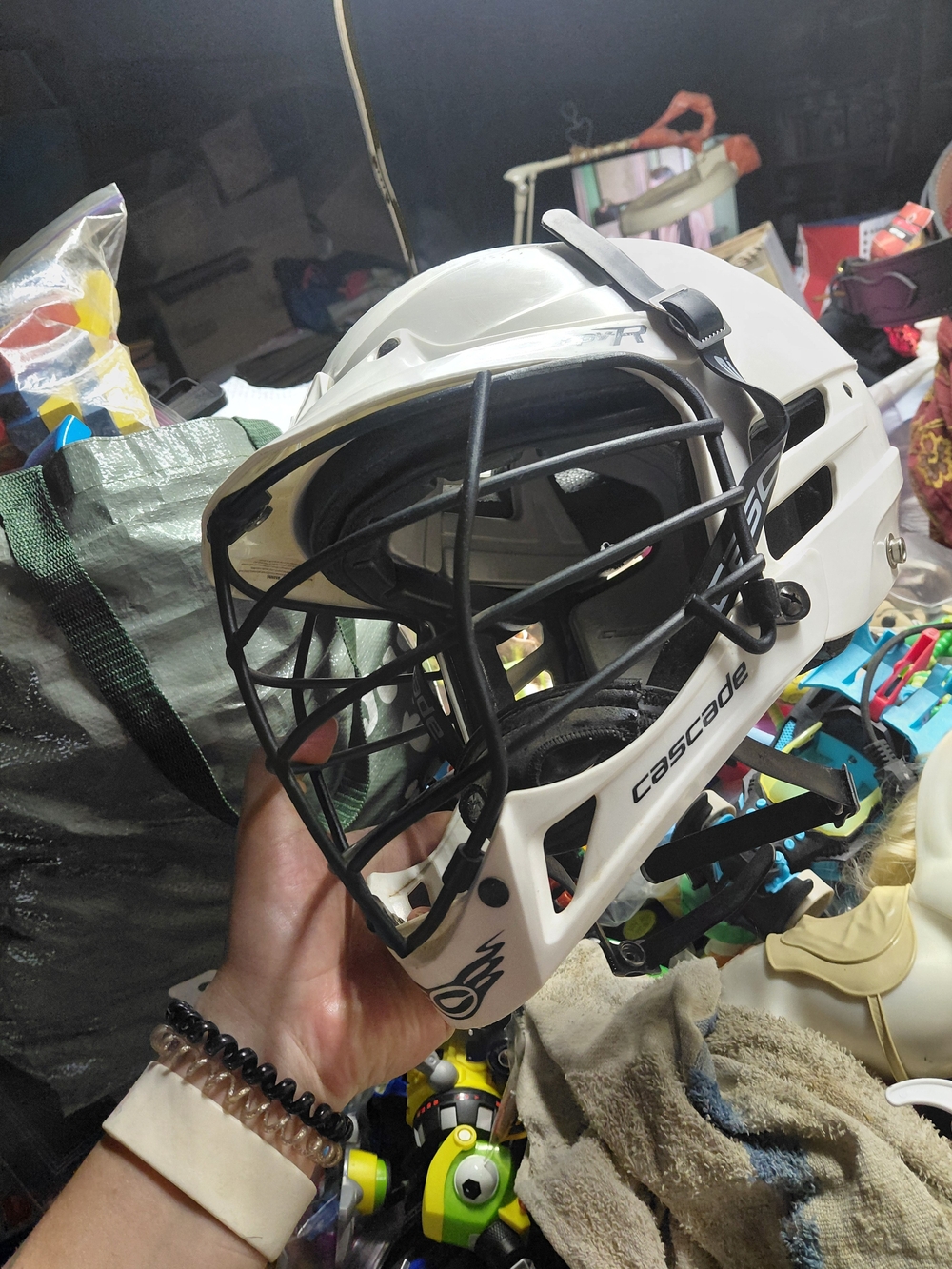 white Cascade lacrosse helmet features a black cage- S/M - R